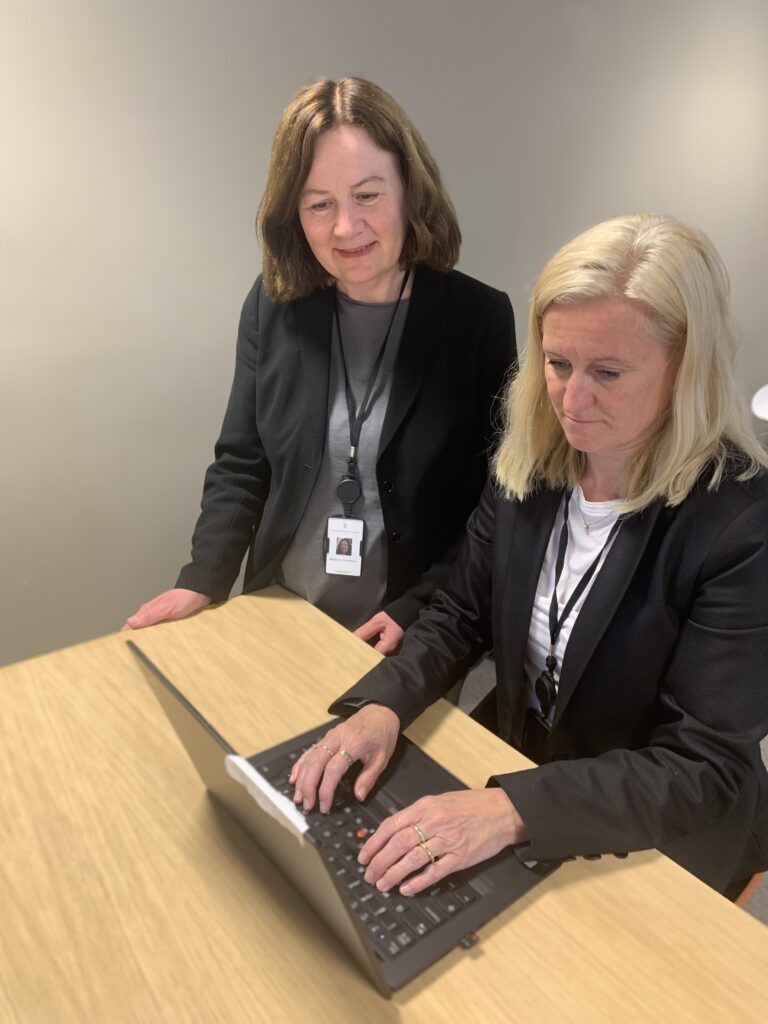 arkivleder og administrasjonssjef ser inn i PC