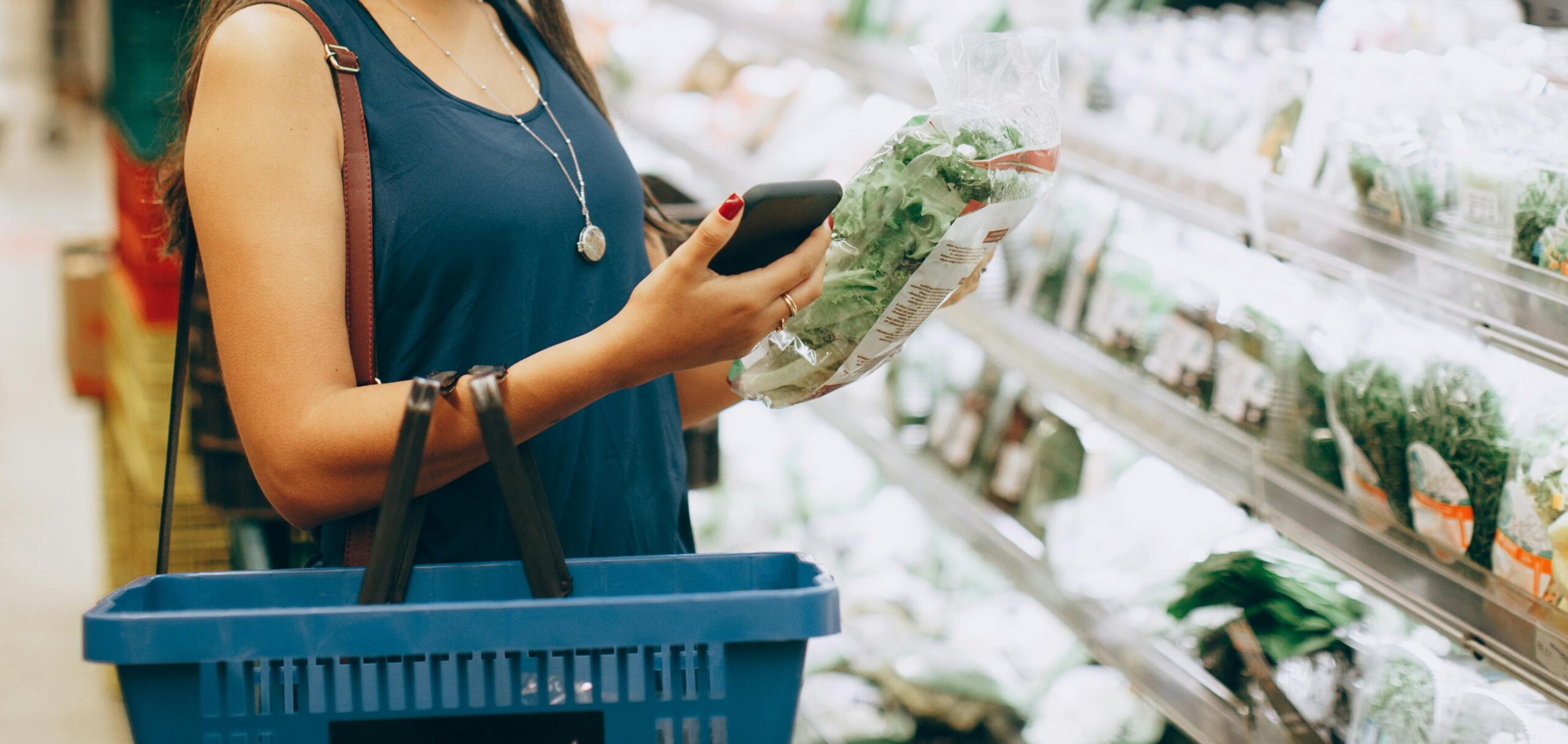 Kvinne sjekker pris på vare i grønnsaksavdelingen